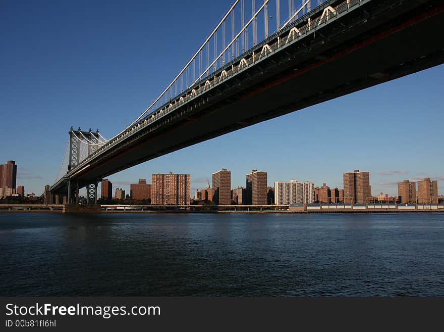 Manhattan bridge and surrounding Manhattan skyline on a clear blue day. Manhattan bridge and surrounding Manhattan skyline on a clear blue day