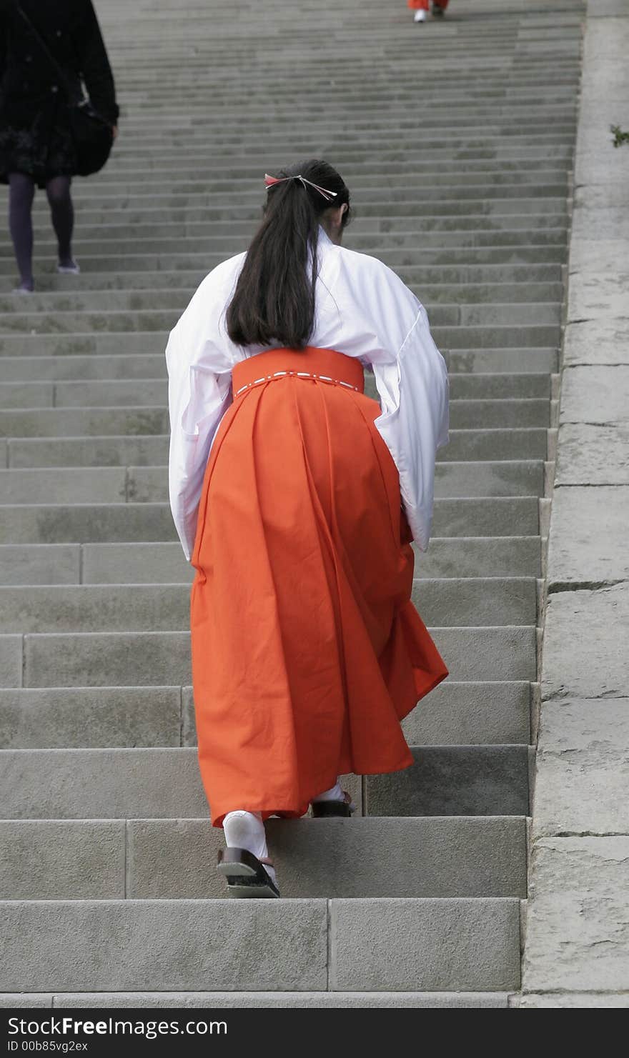 A Japanese lady in tradional costume walking up a steep sairway, Kamakura. Kanagawa-ken, Japan.