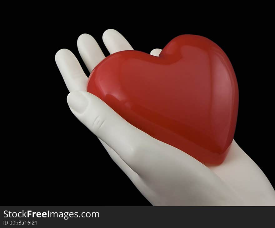 Photo of a hand holding a heart isolated on black. Photo of a hand holding a heart isolated on black