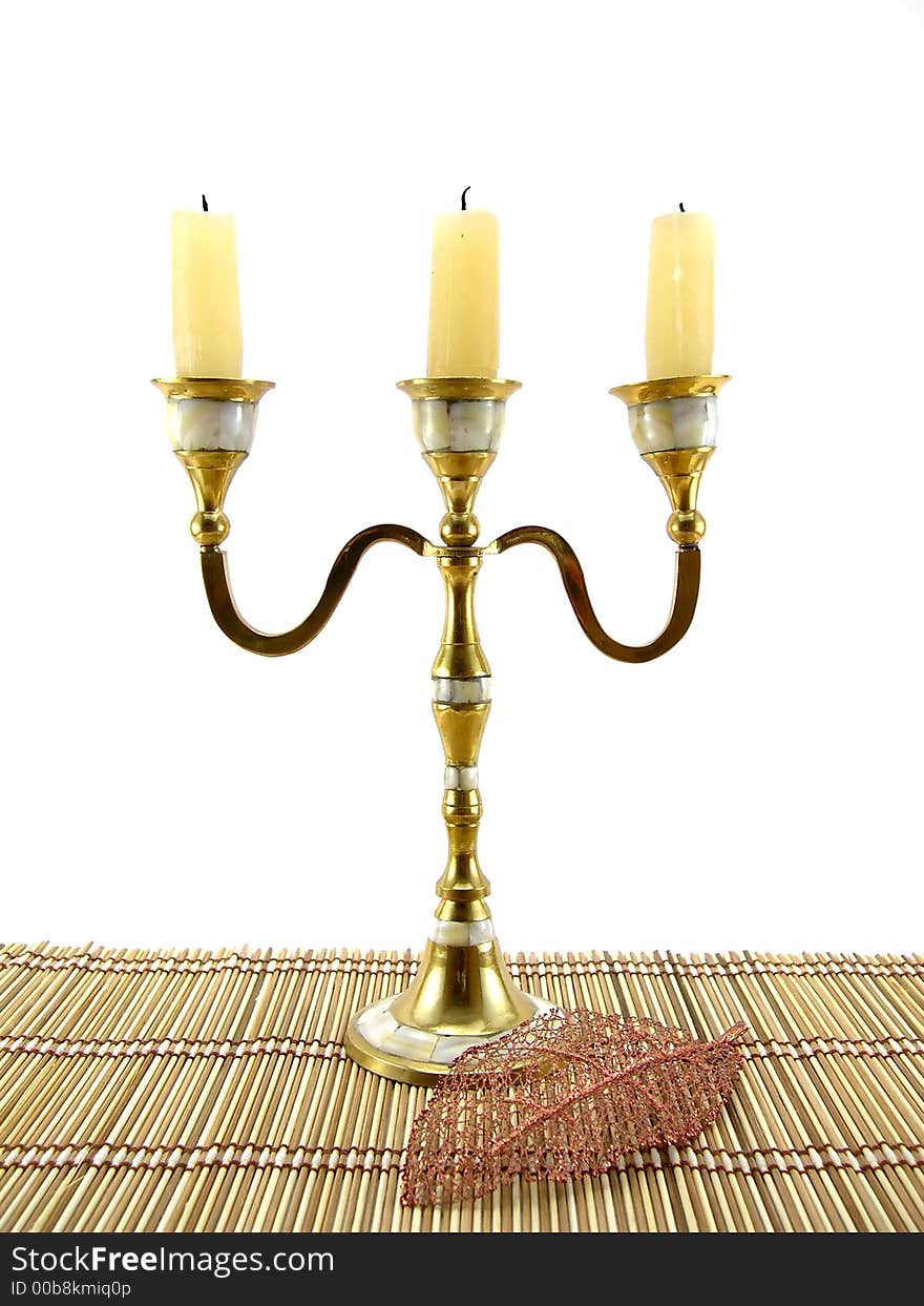 Beautiful candlestick and leaf on a bamboo napkin