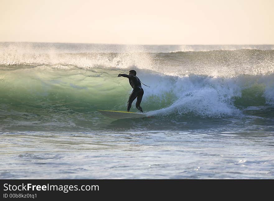 Sunset surfer in the wave