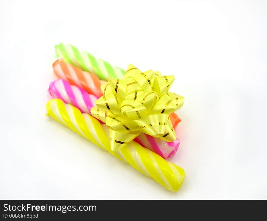 Multi-coloured celebratory candles on a white background