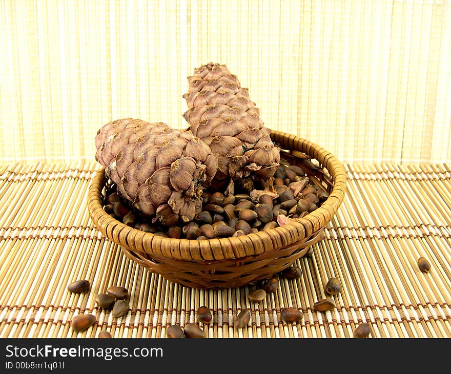 Beautiful cone with nuts on a background of a bamboo napkin