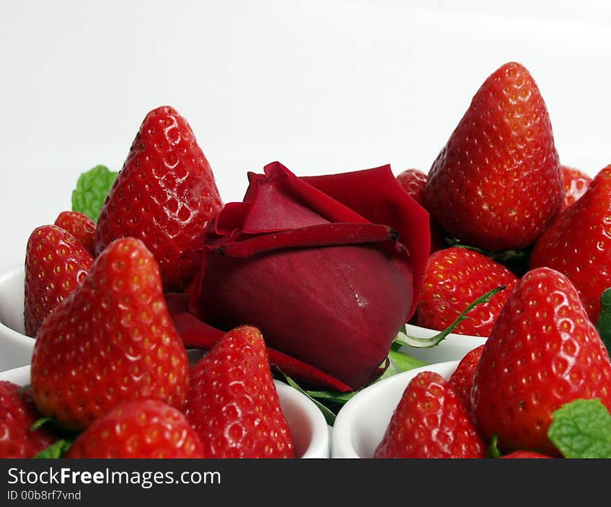 Two strawberry little bowls with mint on white background and one valentine rose