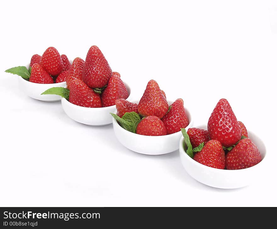 Some strawberry little bowls with mint on white background