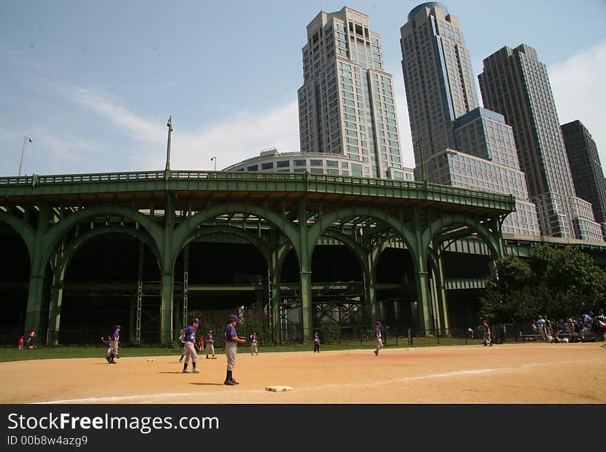 Urban kids playing baseball oblivious to the city. Urban kids playing baseball oblivious to the city.