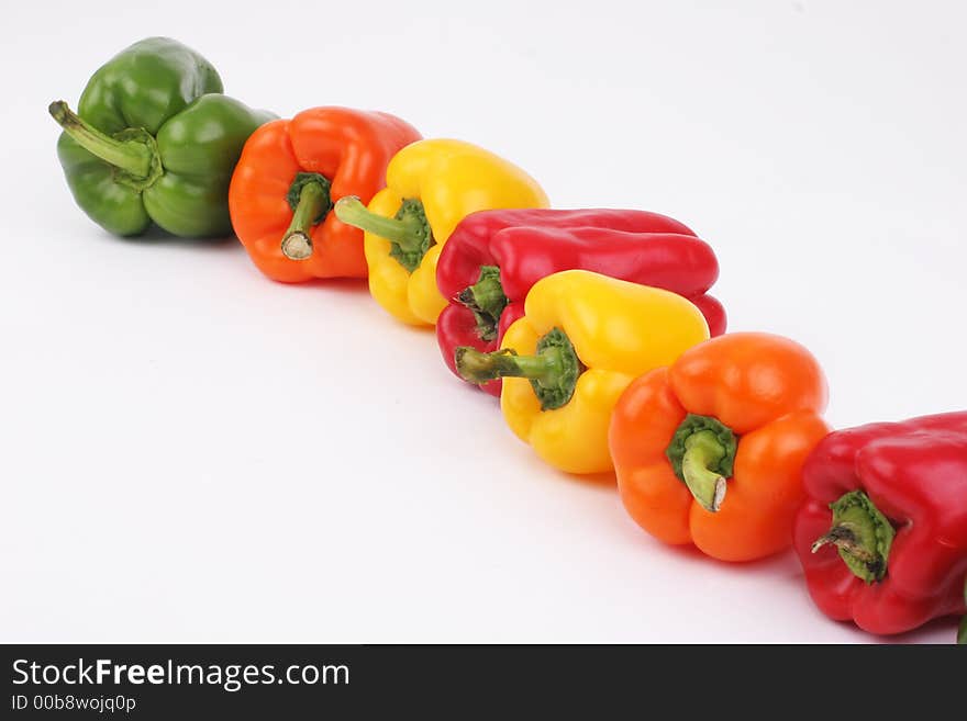 Different colored peppers in a line