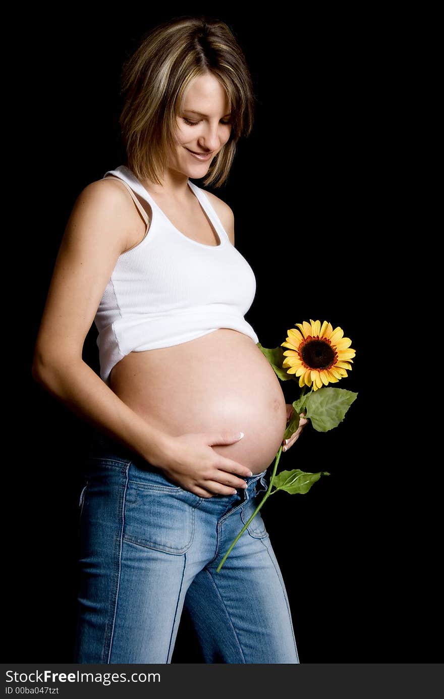 Pregnant woman on black with a sunflower. Pregnant woman on black with a sunflower