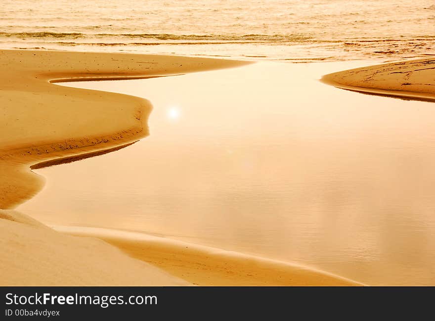 Afternoon sun reflecting on still tide pool with waves behind. Afternoon sun reflecting on still tide pool with waves behind