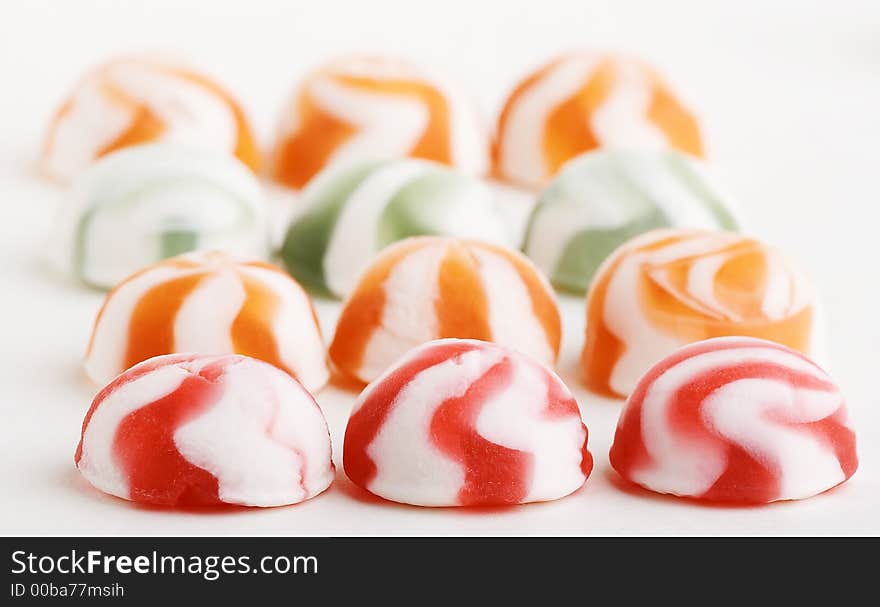 Many not chocolate sweets lay beside close by on white background