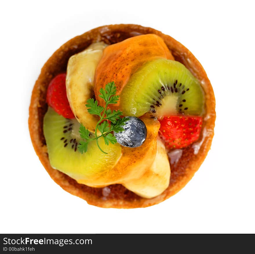 Upper view of a small tasty fruits tart over white background