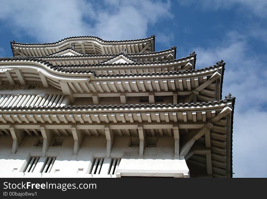 A photo of Himeji Castle's (also known as White Castle) beautiful roof and the sky above it. A photo of Himeji Castle's (also known as White Castle) beautiful roof and the sky above it