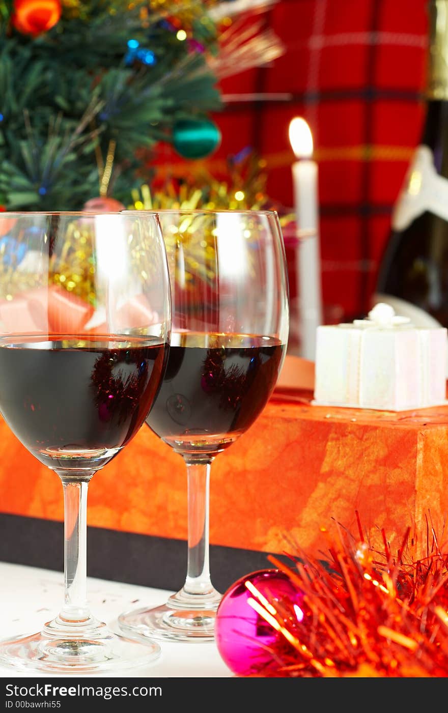 Two glasses with red wine, candles, presents and Christmas tree. Two glasses with red wine, candles, presents and Christmas tree