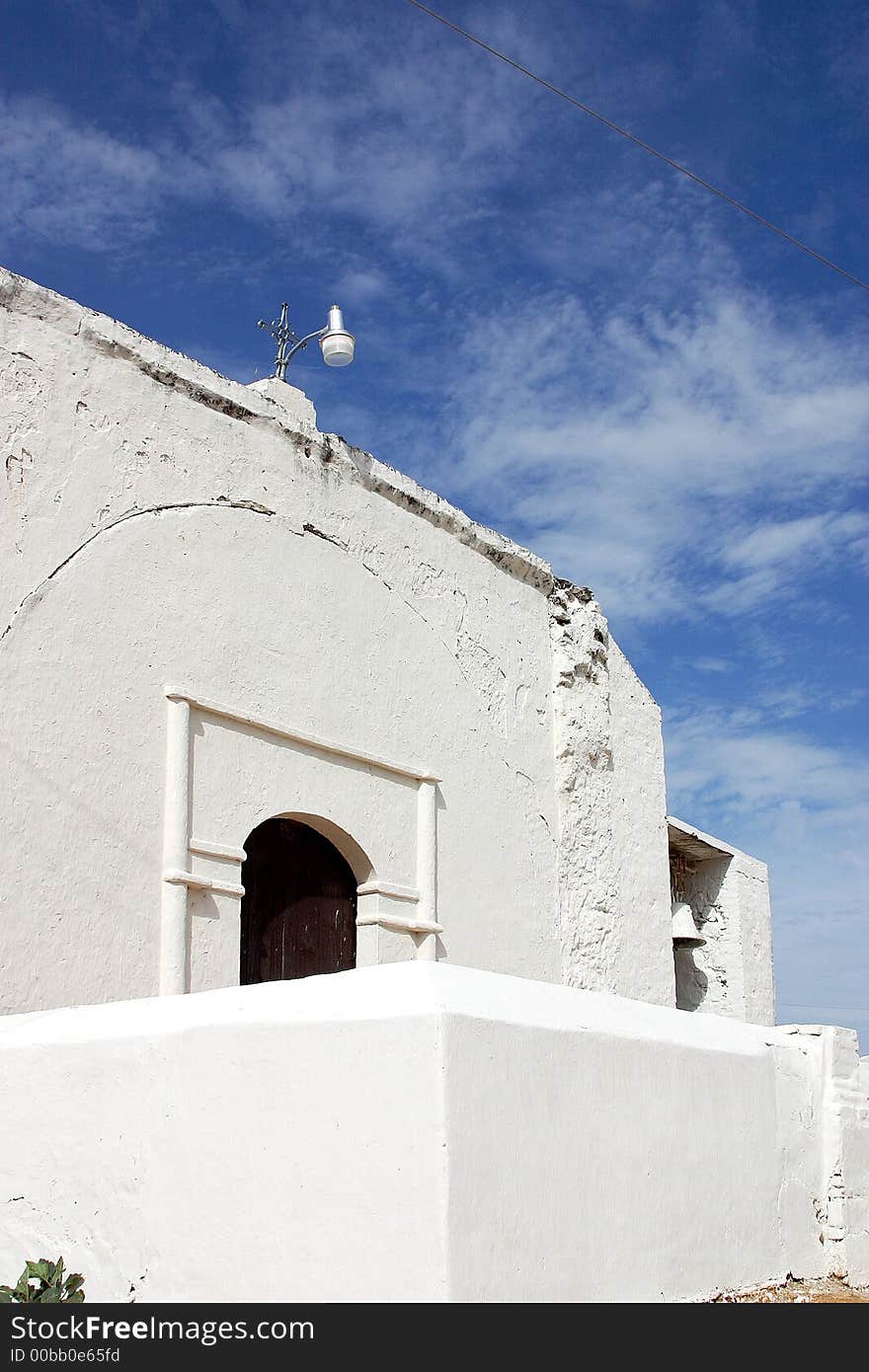 White chapel with cross and the blue sky behind in the town of Alamos, in the northern state of Sonora, Mexico, Latin America