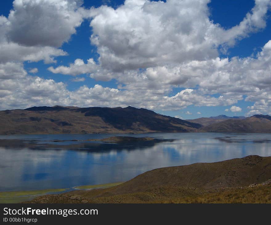 Blue Puffy Clouds  reflected in lake. Blue Puffy Clouds  reflected in lake