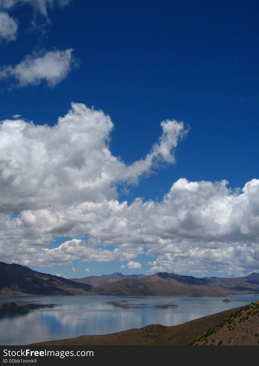 Blue Puffy Clouds  reflected in lake. Blue Puffy Clouds  reflected in lake