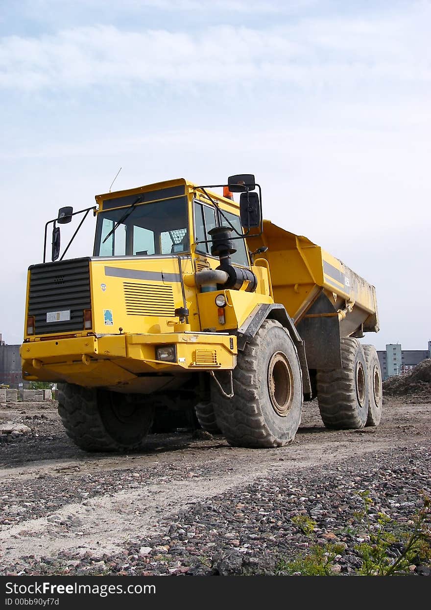 Portrait of dump truck on path with sky background