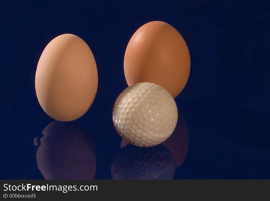 Eggs with golf ball on dark blue background