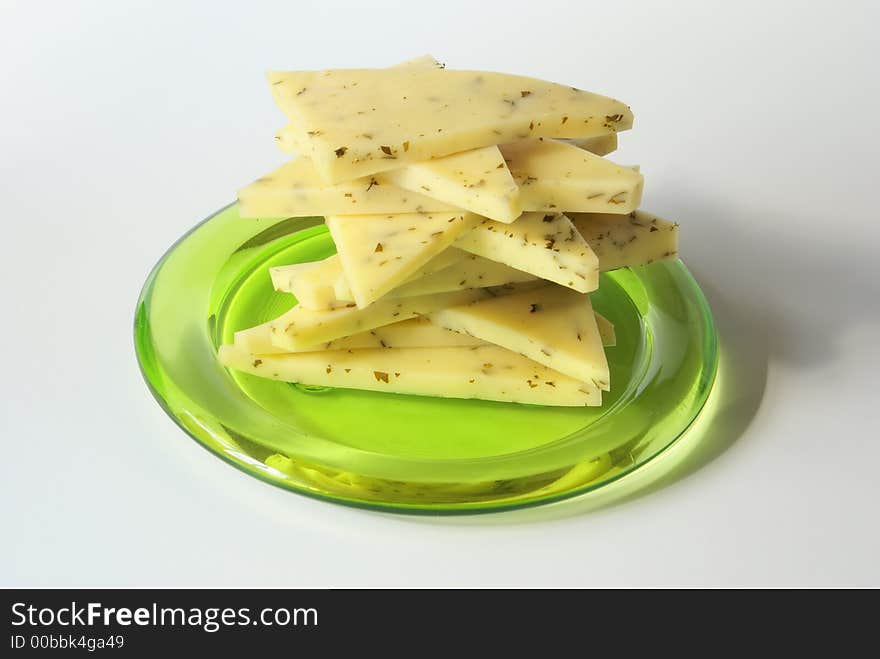 Sliced cheese stack on the green plate close-up