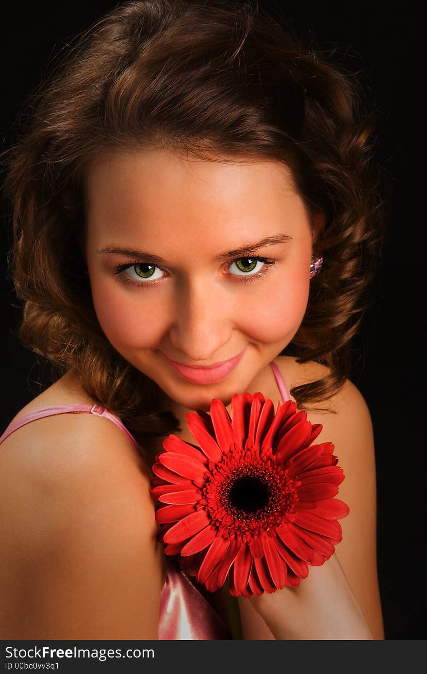 Pretty girl with red flower on black background