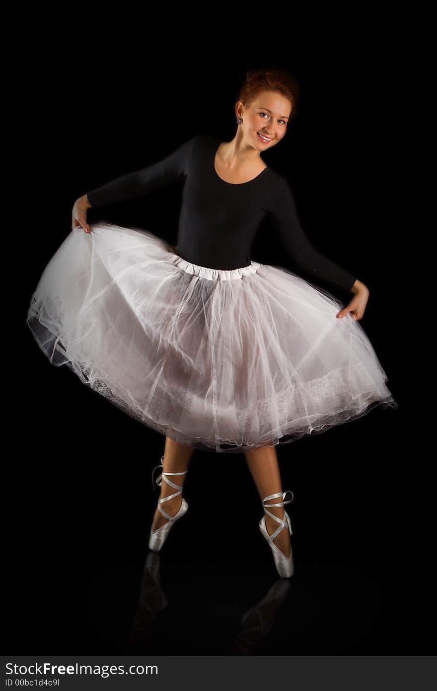 Beautiful girl ballerina to be on points on black background