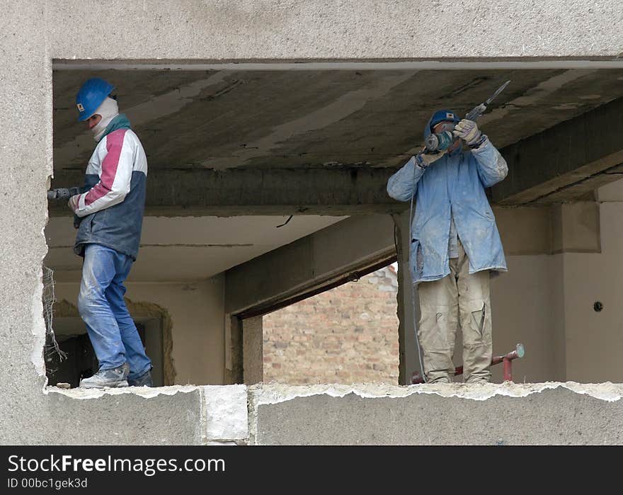 Two worker with pneumatic-drill wreck the old building. Two worker with pneumatic-drill wreck the old building