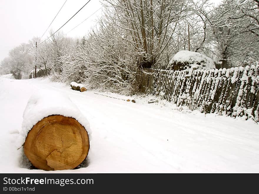 Wood log covered by snow on road. Wood log covered by snow on road