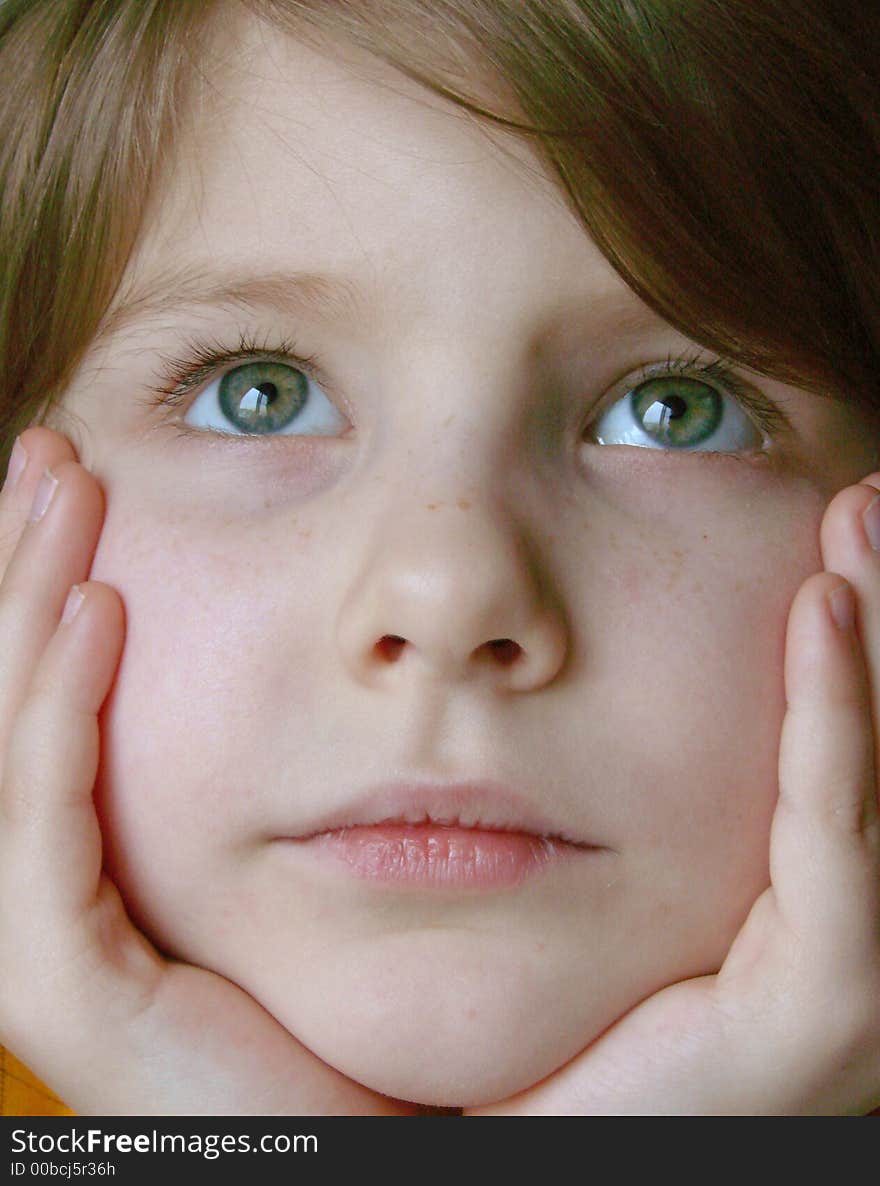 Little pretty thoughtful girl face in hands closeup. Little pretty thoughtful girl face in hands closeup