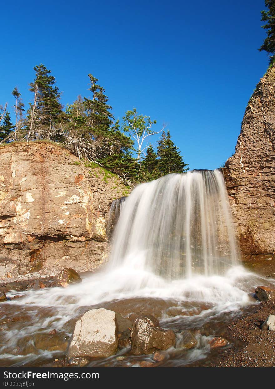 Waterfall to the ocean front view with time lapse. Waterfall to the ocean front view with time lapse