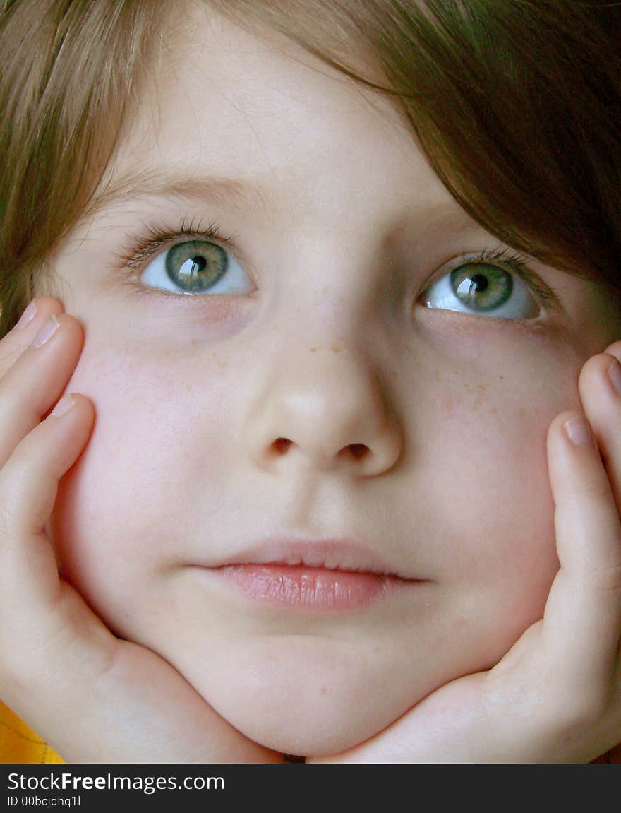 Little pretty dreaming girl face in hands closeup. Little pretty dreaming girl face in hands closeup