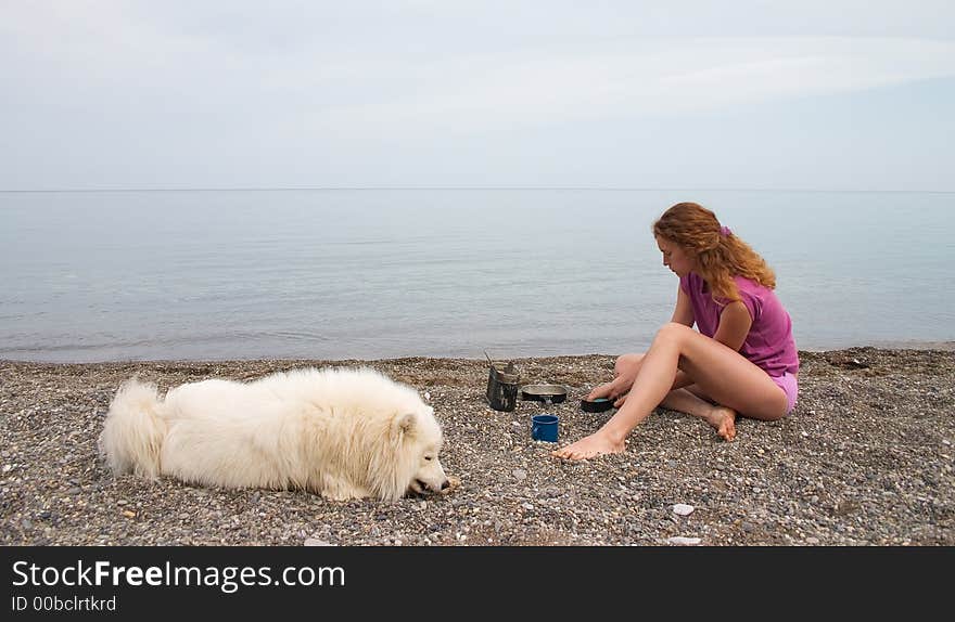 Girl and samoyed on the seaside