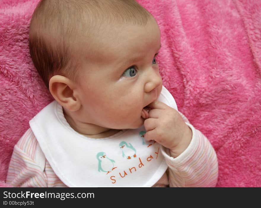 A baby on a pink blanket. A baby on a pink blanket