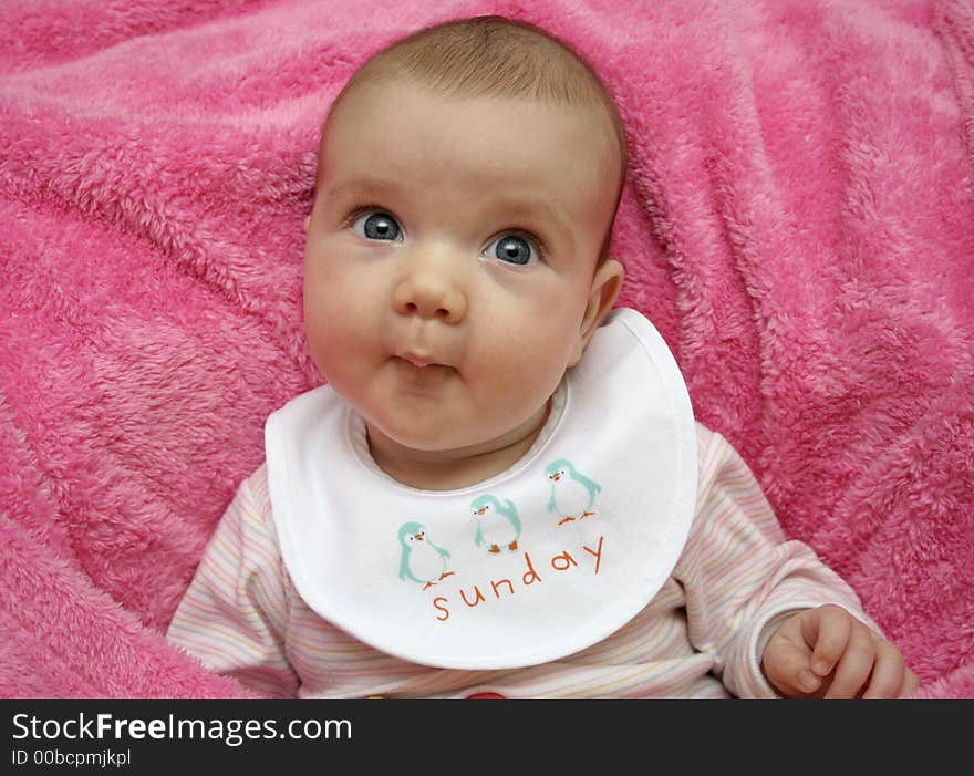 A baby on a pink blanket. A baby on a pink blanket