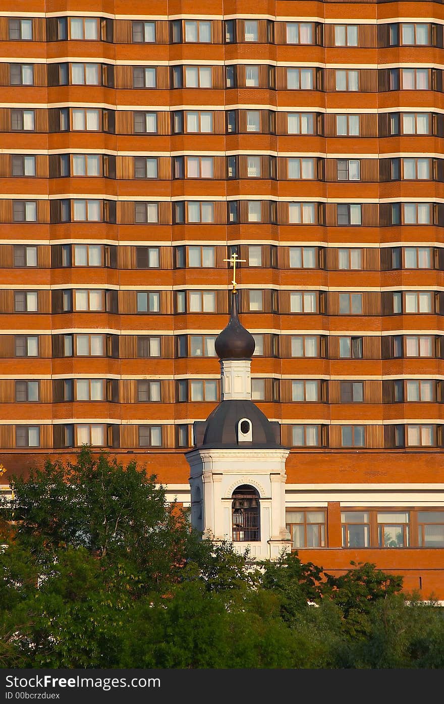 Small church on a background of huge hotel