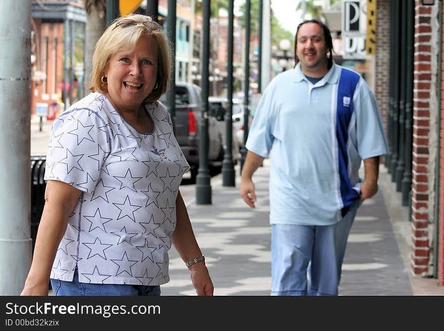 Photo of a young man walking down the sidewalk, happy to see his friend. Photo of a young man walking down the sidewalk, happy to see his friend