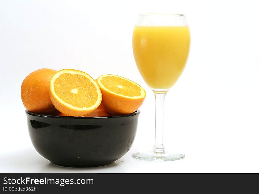 Shot of orange juice & oranges on white. Shot of orange juice & oranges on white