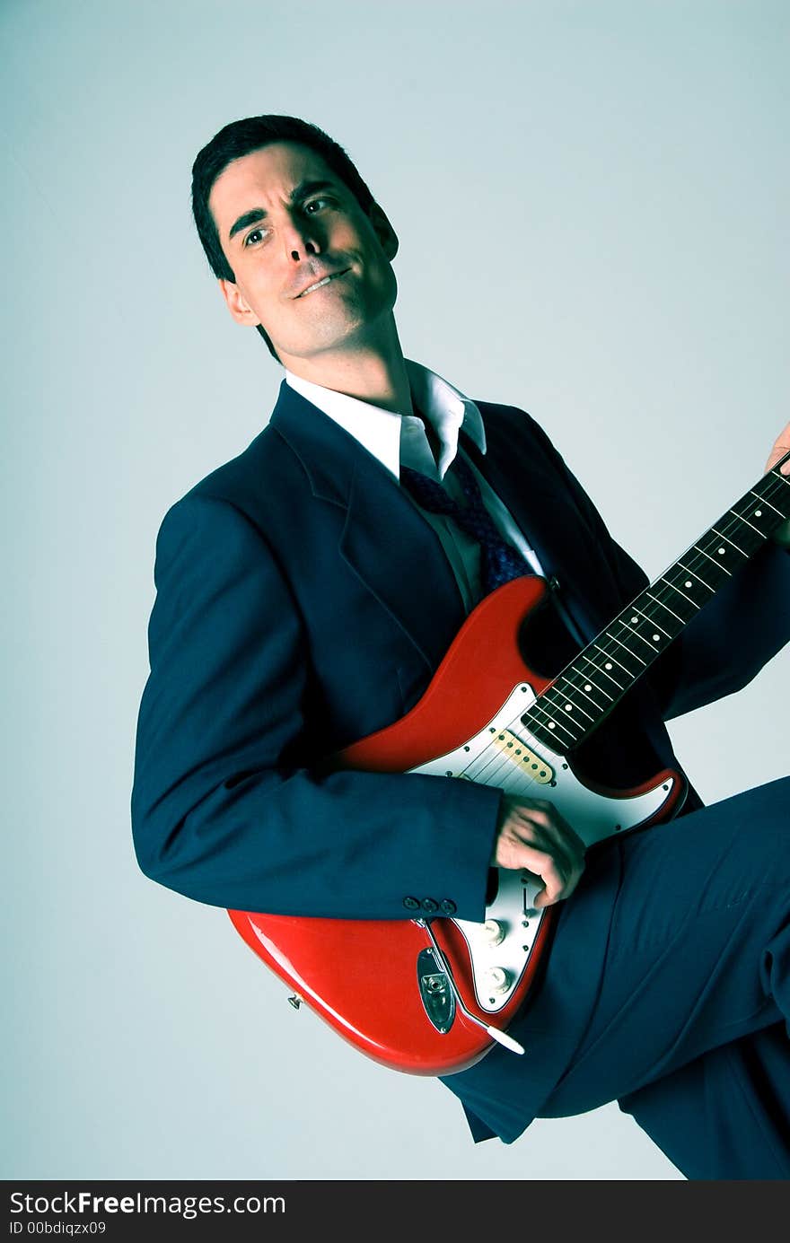 Man in blue suit with a red guitar. Man in blue suit with a red guitar