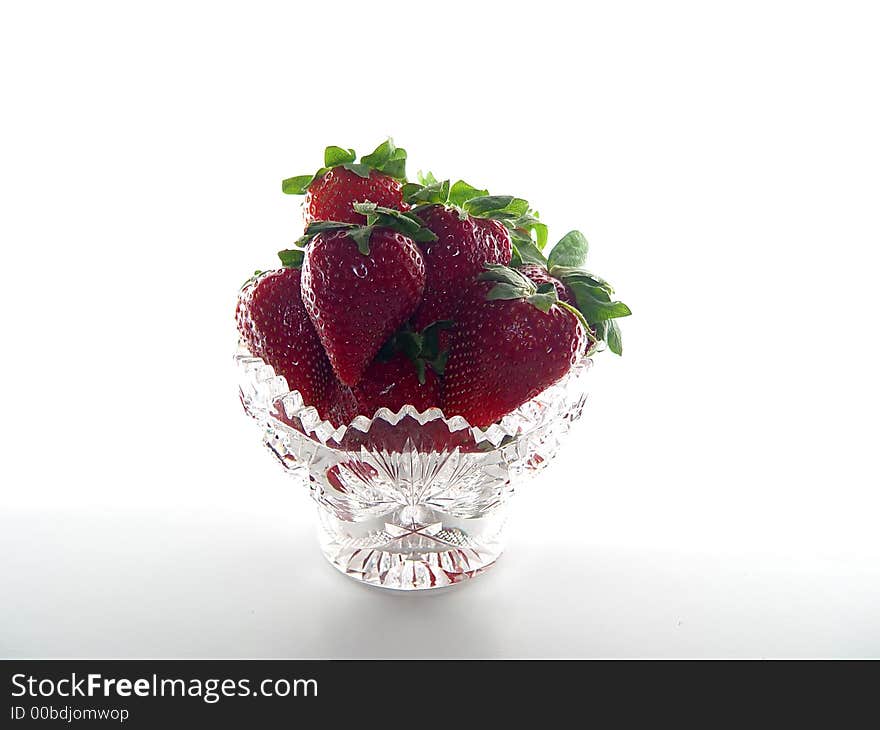 Crystal bowl filled with strawberries on white background. Crystal bowl filled with strawberries on white background.