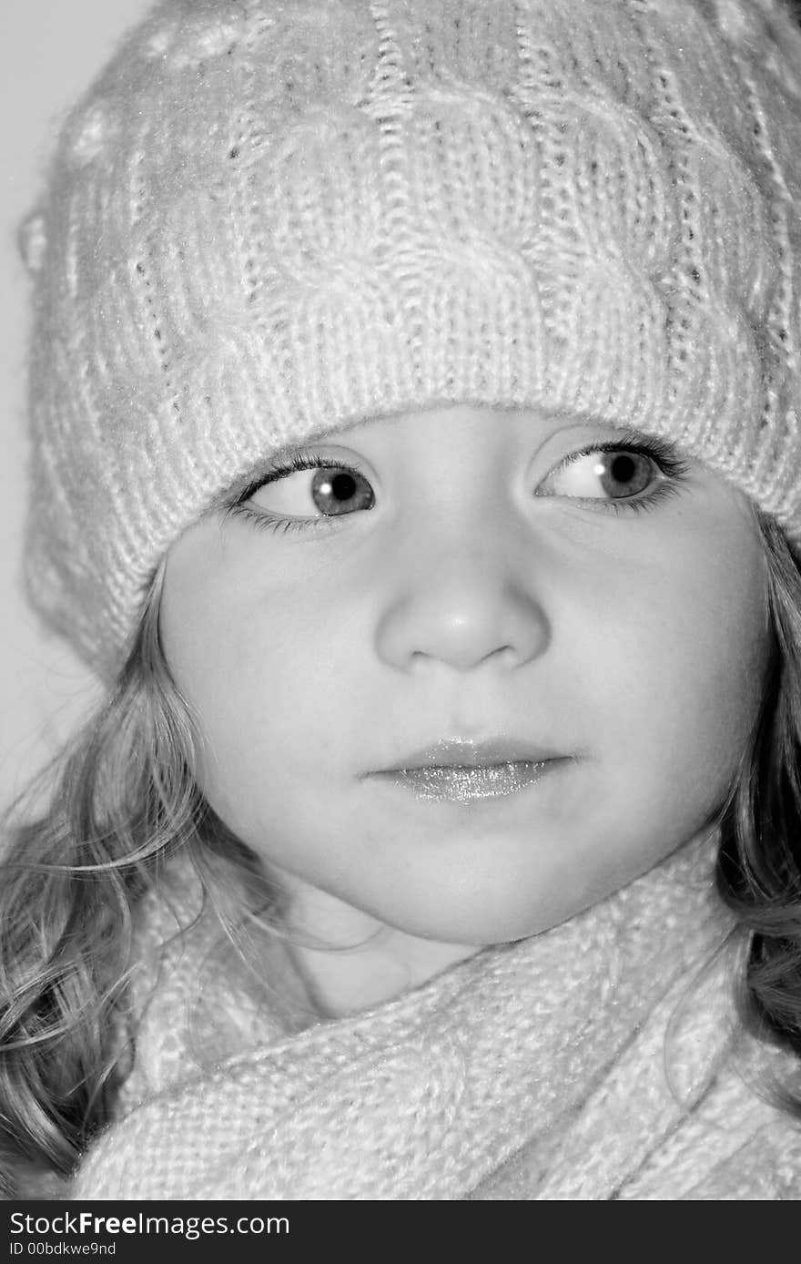 Cute girl with matching hat and scarf looking to the side in black and white. Cute girl with matching hat and scarf looking to the side in black and white