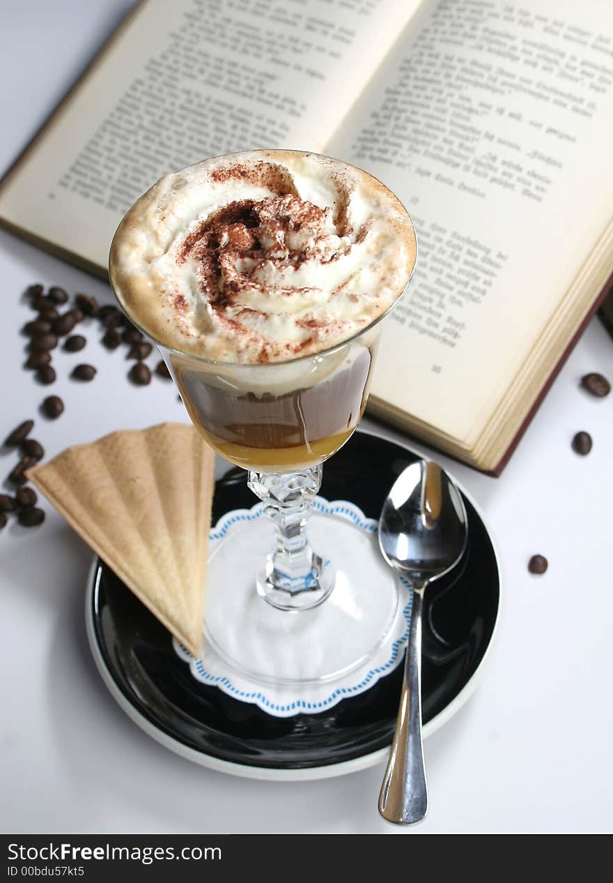 Chocholate with whipped cream in the cristal glass near the book. Chocholate with whipped cream in the cristal glass near the book