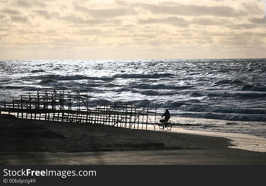 The man on a bicycle goes on seacoast