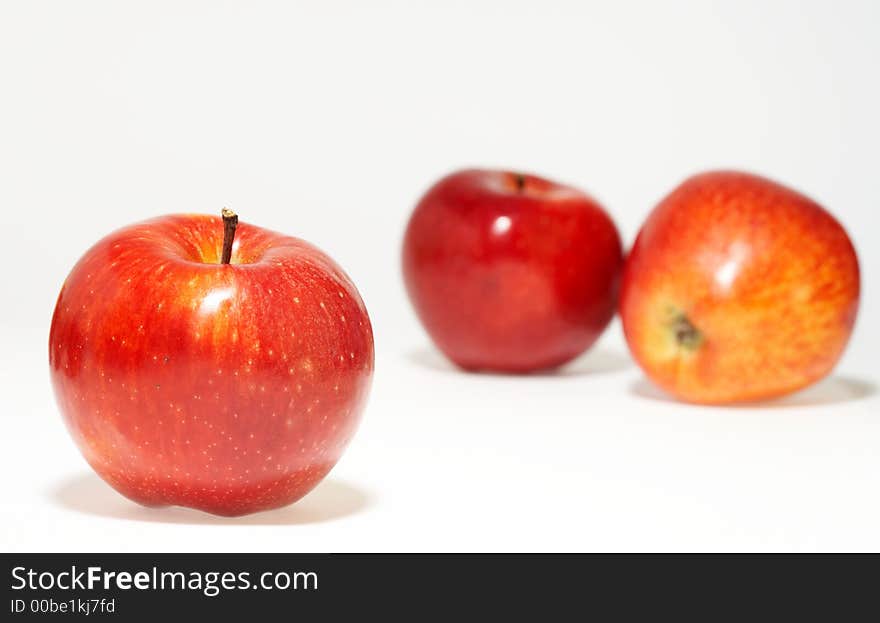 Three nice red juicy apples on white sheet. Three nice red juicy apples on white sheet