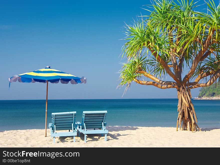 View of two chairs and umbrella on the beach. View of two chairs and umbrella on the beach