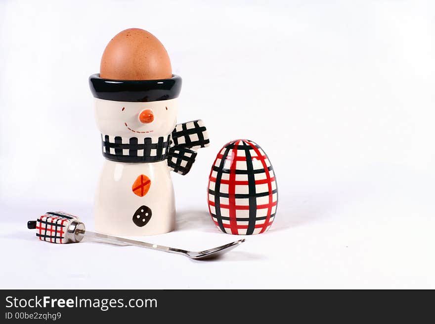 Egg in a happy egg cup with spoon and salt pot. Egg in a happy egg cup with spoon and salt pot.