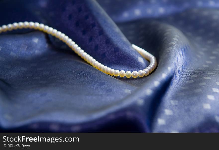 Pearl necklace on dark blue silk