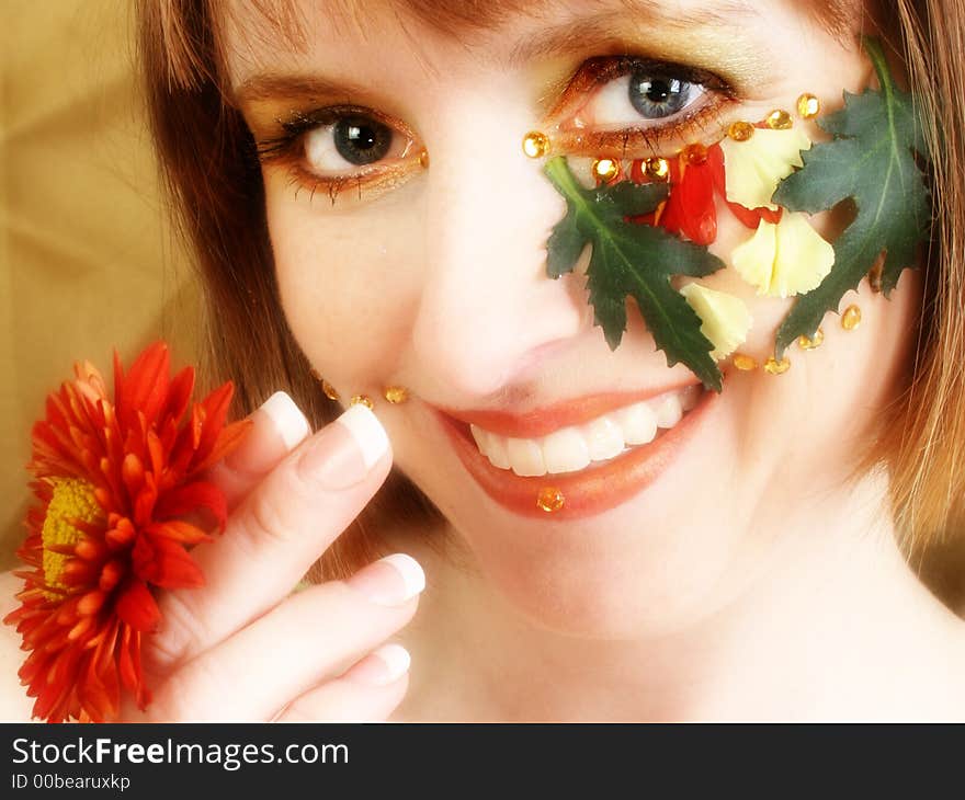 Beautiful thirty something woman with autumn flowers decorating face. Beautiful thirty something woman with autumn flowers decorating face.