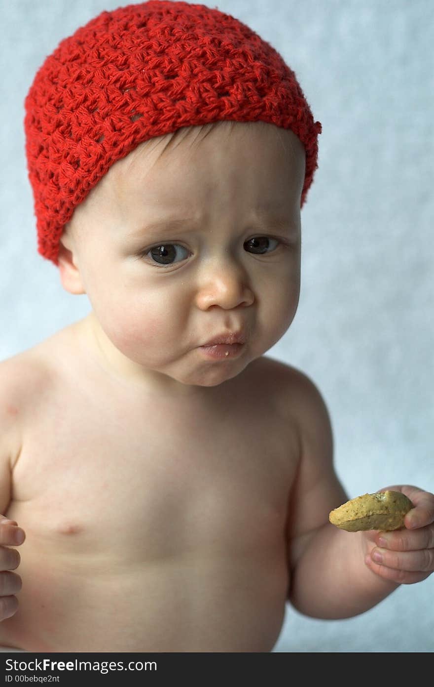 Image of 9 month old infant eating a baby cookie