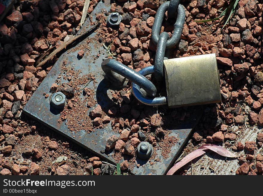 Steel chain locked into gravel ground, hot weather