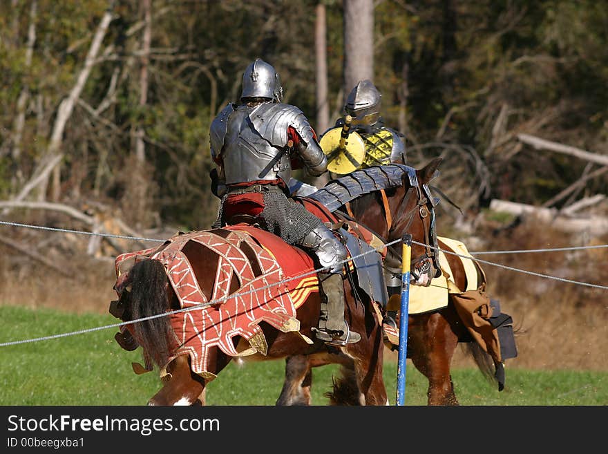 Jousting knights prepare to cladh on horseback.