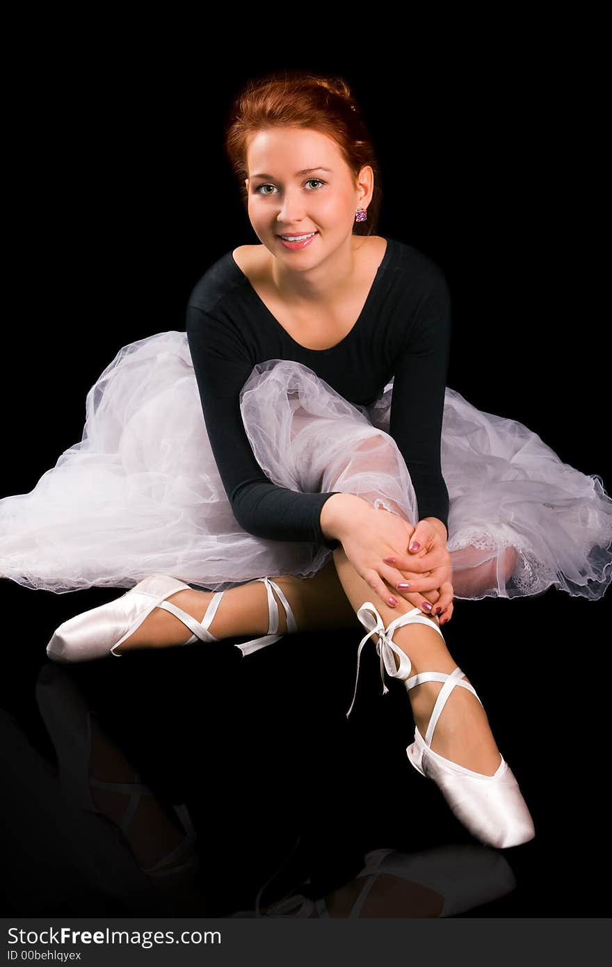 Beautiful girl ballerina to be on points on black background